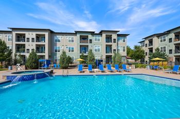A swimming pool in front of apartment buildings.